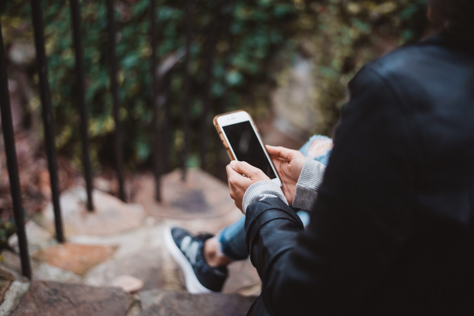 Someone sitting on a stair and with their phone